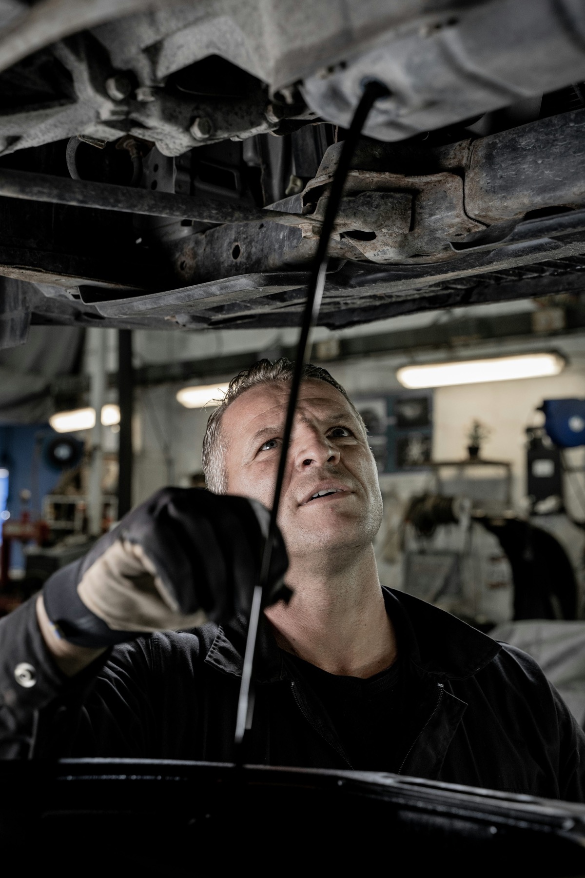 Mechanic working on an engine to illustrate automotive after-sales management