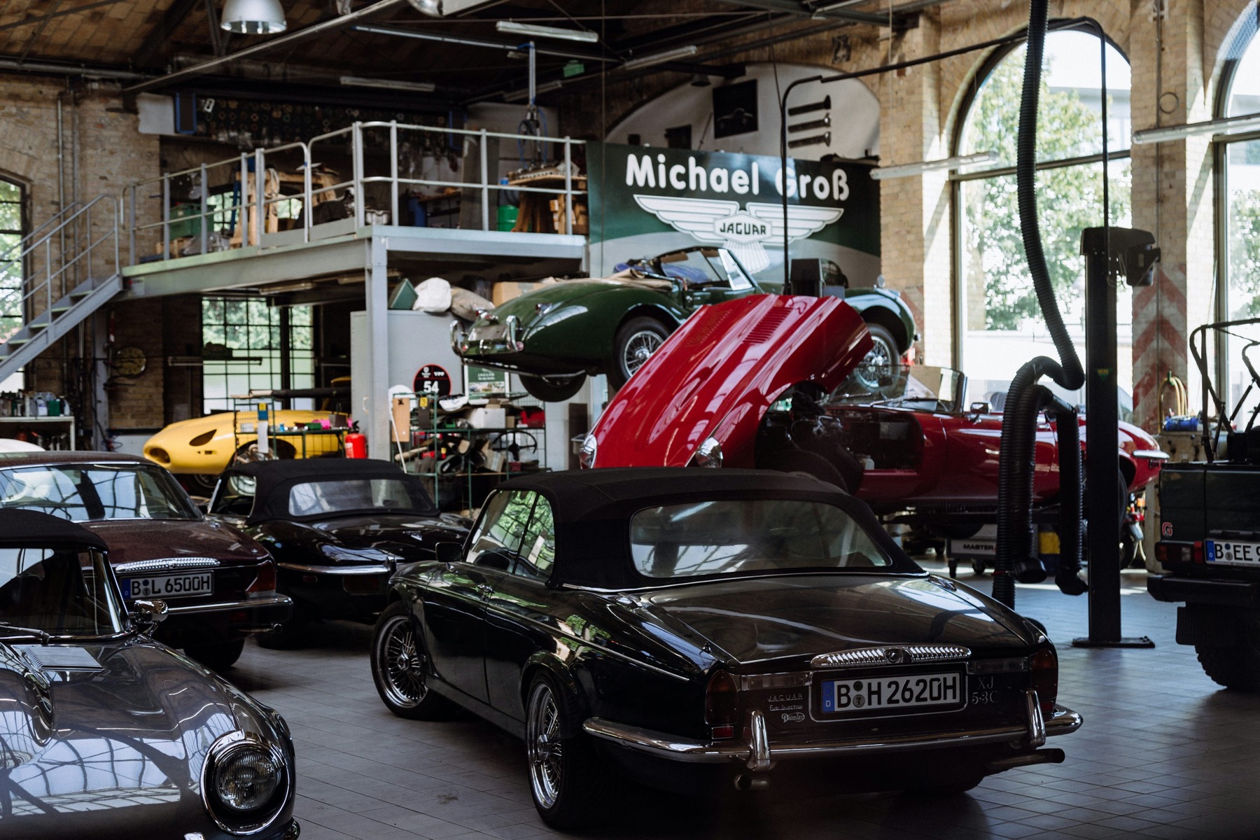Automotive workshop with several vehicles under service to illustrate workshop management software