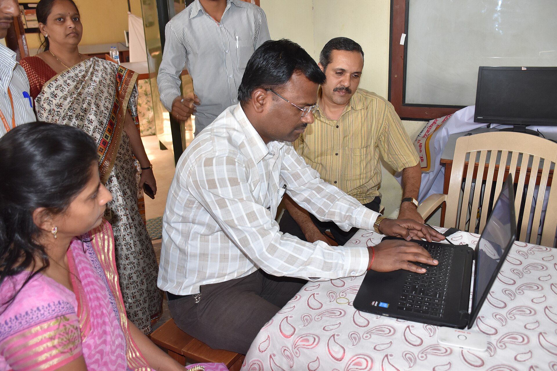 Trainer and learners in a clear training setting to illustrate a dedicated portal